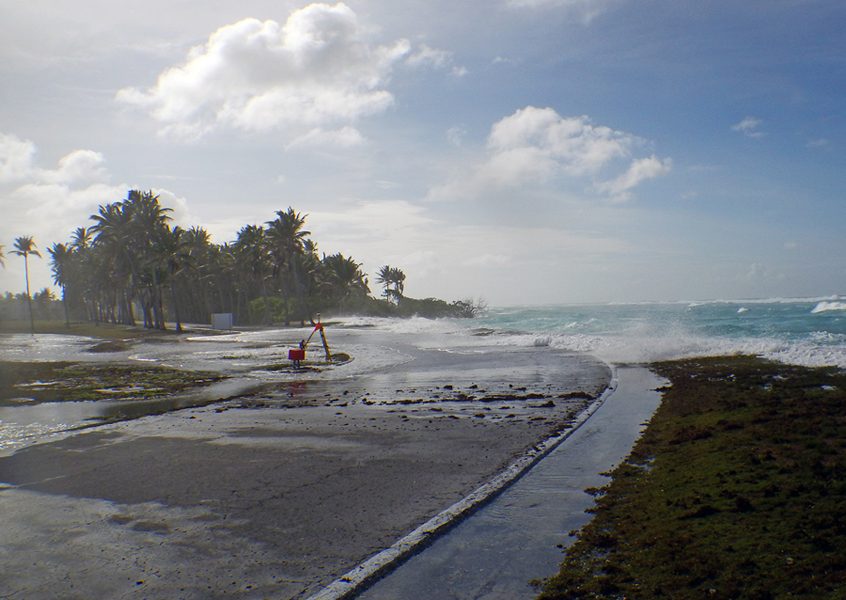 Waves wash over a flat coastal zone of Roi-Namur Atoll